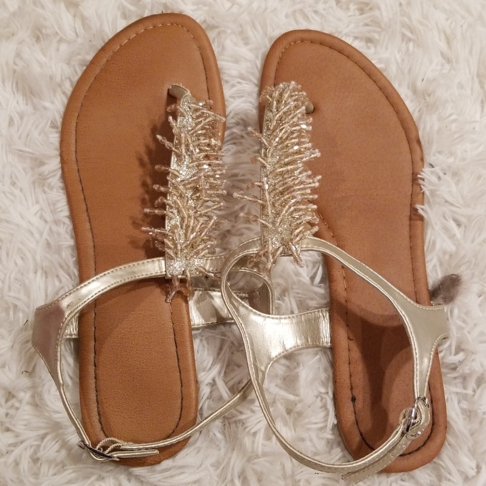 Gold and tan glitter sandals worn